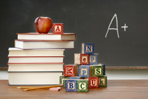 teacher books, blocks, and apple in front of chalkboard