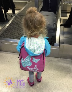 little girl with butterfly backpack at the airport