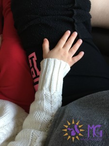 little girl's hand on mom's leg