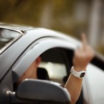 young driver shows middle finger