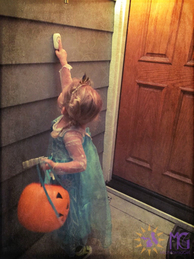 girl in Elsa costume trick-or-treating