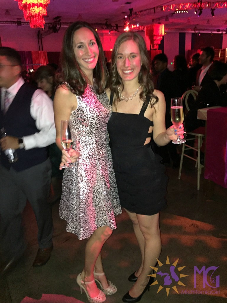 two women in dresses holding champagne
