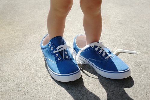 space between baby and boy baby feet in big shoes