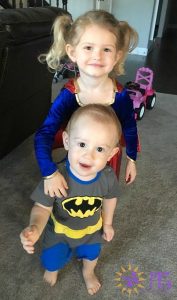 girl and boy dressed up in halloween costumes as supergirl and batman diary of a dog